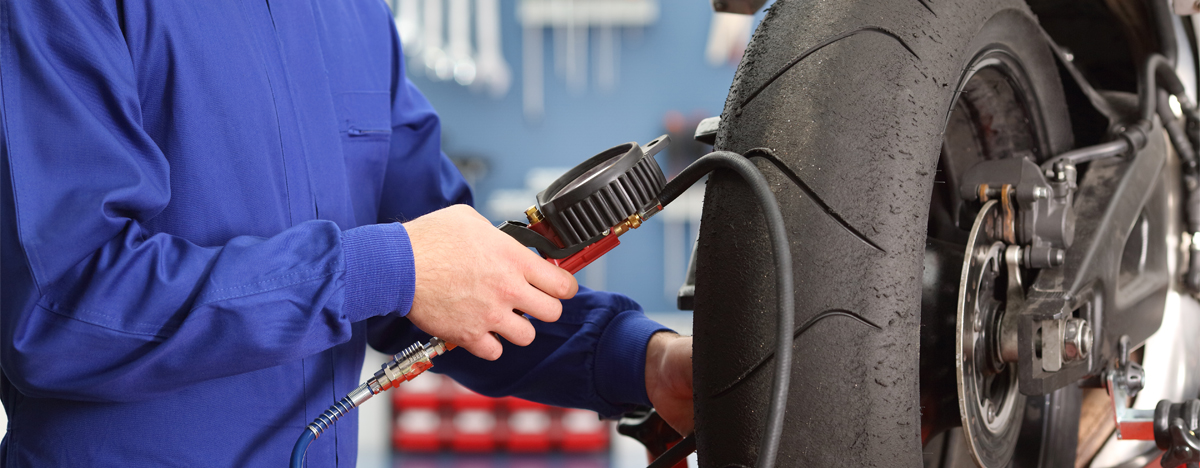 Mechanic checking a bike tyre - Motorcycle Tyres Basingstoke